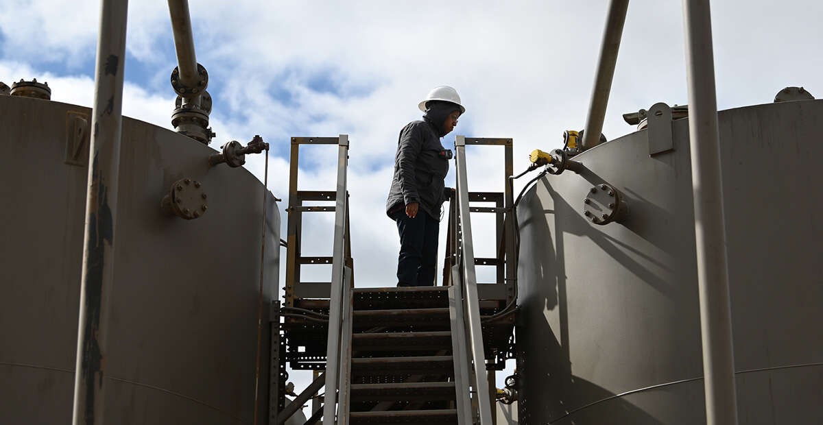 person at the top of the stairs looking at a large tank