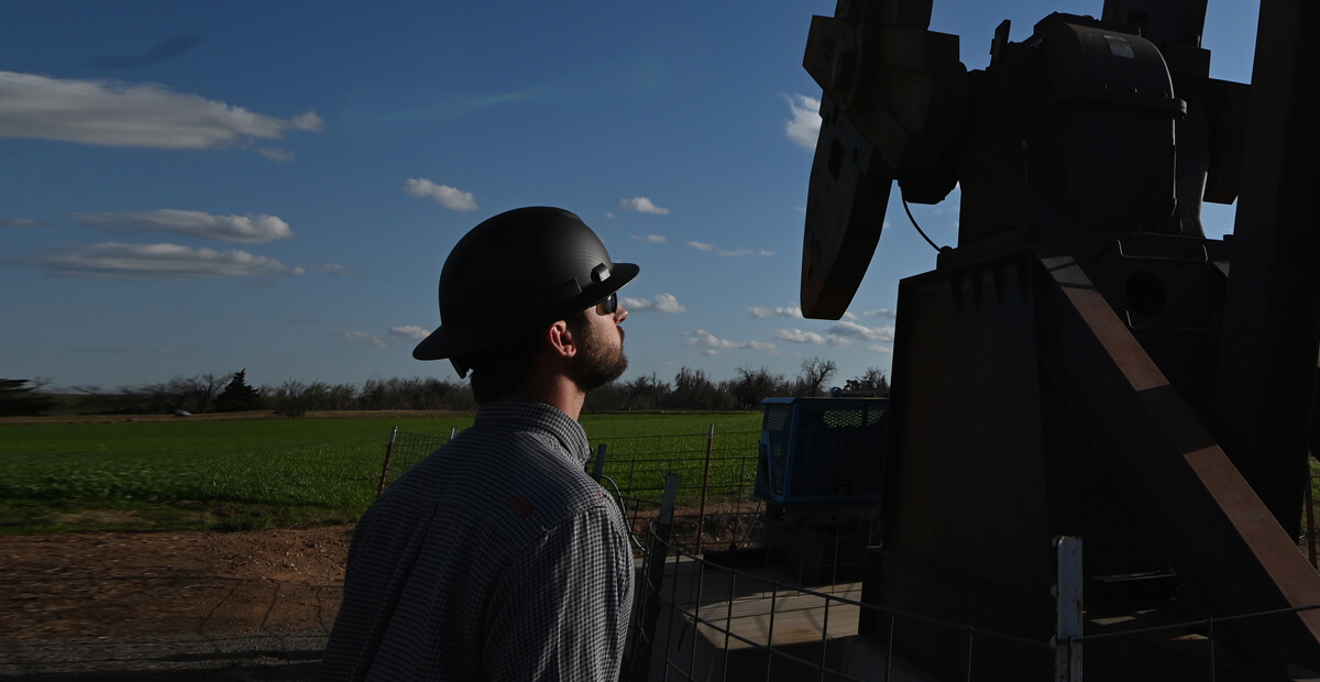 man inspecting an oil well
